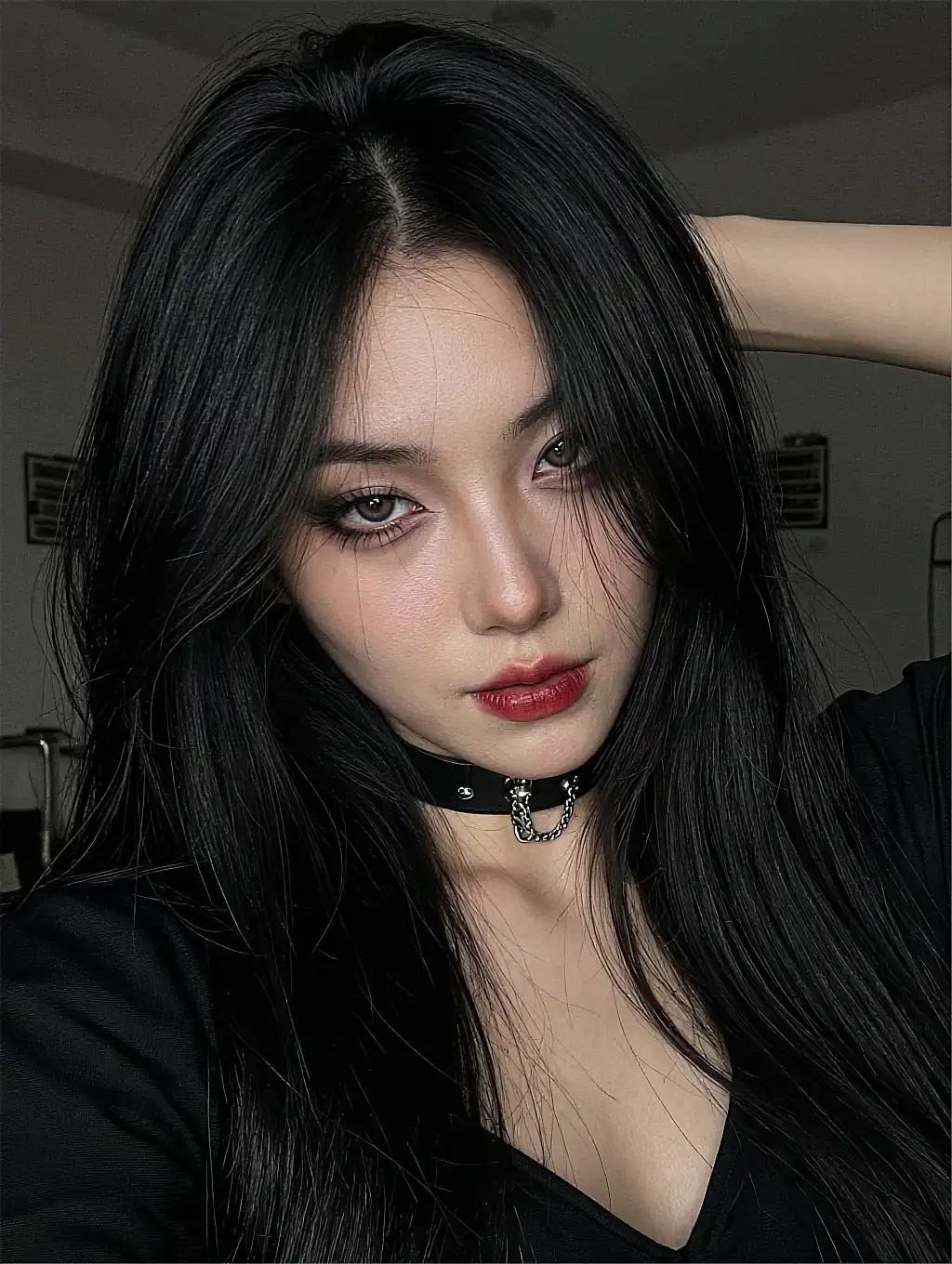Fictional AI character with black hair, red lips and a choker, looking into the camera